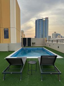 a swimming pool on the roof of a building at Amfas Suites أمفاس سويتس in Manama