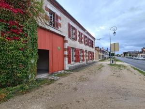 an empty street next to a building with a red garage at Gîte Bellegarde, 4 pièces, 6 personnes - FR-1-590-2 in Bellegarde-du-Loiret