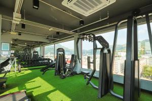 un gimnasio con alfombras verdes y máquinas de correr en un edificio en Gu Hotel Patong, en Patong Beach