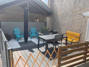 a patio with a table and chairs and a fence at Gîte chaleureux avec terrasse près de Nancy, parking privé, à proximité de festivals et nature - FR-1-584-9 in Domptail-en lʼAir