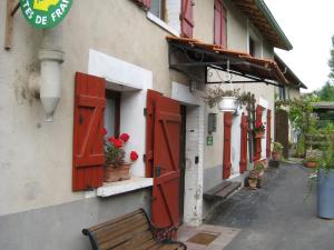 a bench sitting outside of a building with red doors at Gîte Charmant avec Cheminée, Terrasse et Stationnement - Proche Nancy et Moselle - FR-1-584-50 in Tonnoy