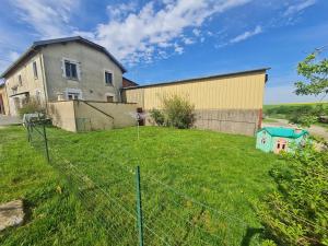 ein großes Gebäude mit einem Zaun vor einem Hof in der Unterkunft Gîte familial et équipé à la campagne avec terrasse, près de Pont-à-Mousson et de nombreuses activités - FR-1-584-73 in Lironville