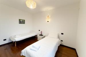 two beds in a room with white walls at 5min RhoFiera~10minMetro~Parking in Pero