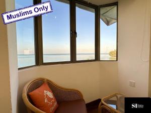 a room with windows and a chair with a sign that reads muslins only at Waves Bliss - Seaside Serenity - 3BR2B 8 pax by Cowidea in Port Dickson