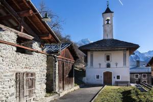 a small white building with a clock tower on top at Face aux 3 vallées in Bozel