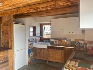 a kitchen with wooden cabinets and a white refrigerator at Face aux 3 vallées in Bozel