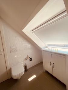 uma casa de banho com um WC branco e uma janela em Clemanbruges em Bruges