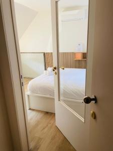 uma porta que leva a um quarto com uma cama em Clemanbruges em Bruges