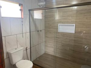 uma casa de banho com um WC e uma cabina de duche em vidro. em Chalés Canto Das Águas em Bueno Brandão