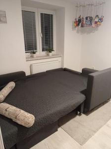 a black bed in a room with a window at chalupa in Žďár nad Sázavou