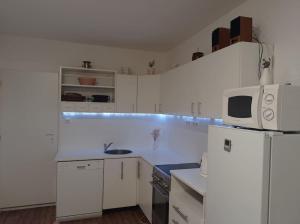 a white kitchen with a microwave and a refrigerator at chalupa in Žďár nad Sázavou
