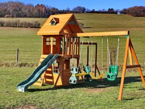 a playground with a slide and swings in a field at Gîte Culey, 3 pièces, 4 personnes - FR-1-585-24 in Culey