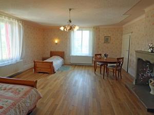 een slaapkamer met een bed en een tafel en een bed en een kamer bij Gîte Bellefontaine, 6 pièces, 12 personnes - FR-1-589-40 in Bellefontaine