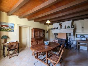 een eetkamer met een houten tafel en een open haard bij Gîte Saint-Amand-sur-Ornain, 4 pièces, 6 personnes - FR-1-585-56 