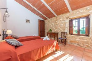 a bedroom with two beds and a stone wall at S'Alqueria Rotja in Santanyi +37 photos