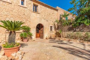 a stone building with a door and some plants at S'Alqueria Rotja in Santanyi
