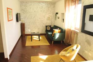 a living room with a couch and a chair at Capital House Roma in Rome