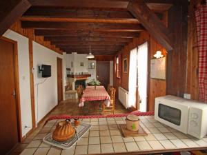 a living room with a microwave and a table at Gîte Champdray, 3 pièces, 4 personnes - FR-1-589-64 in Champdray