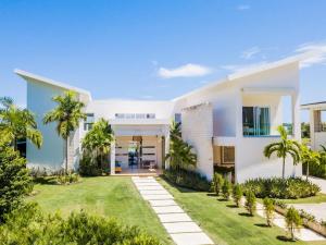 una casa blanca con palmeras y un patio en Kosher casa en Punta Cana