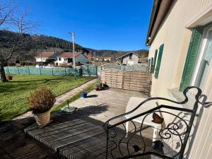 BiffontaineにあるGîte cozy au cœur des Vosges : terrasse, jardin, proche Gérardmer, animaux bienvenus - FR-1-589-76の塀付きのデッキのベンチ付きポーチ