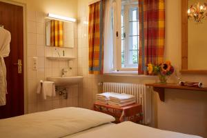 un piccolo bagno con letto e lavandino di Gästehaus Englischer Garten a Monaco