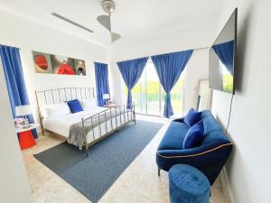1 dormitorio con 1 cama y 1 sofá azul en Kosher casa en Punta Cana