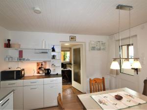 una cocina con armarios blancos y una mesa en una habitación en Apartment Wollbell by Interhome, 
