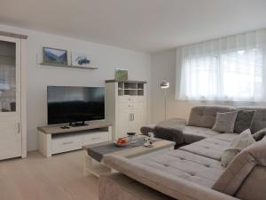 a living room with a couch and a flat screen tv at Apartment Feldli by Interhome in Meiringen