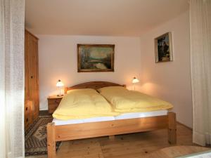 1 dormitorio con 1 cama con sábanas amarillas y 2 lámparas en Apartment Wollbell by Interhome, 