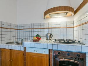 een keuken met een fornuis bovenoven naast een gootsteen bij Apartment Siby-1 by Interhome in Casale Marittimo