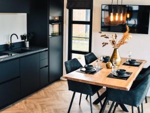 een keuken met een houten tafel en zwarte kasten bij Holiday Home MarinaPark Nieuw Loosdrecht-1 by Interhome in Loosdrecht