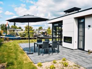 a patio with a table and chairs and an umbrella at Holiday Home MarinaPark Nieuw Loosdrecht-1 by Interhome in Loosdrecht