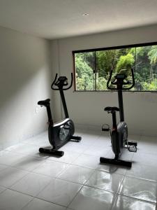 um ginásio com duas bicicletas de exercício num quarto em Apart-hotel Nova Friburgo Com café da manhã em Nova Friburgo