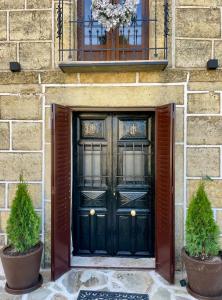 una puerta verde en un edificio con dos macetas en La Casa del Cantero, en Pinilla del Valle