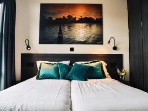 um quarto com uma cama com uma fotografia na parede em Holiday Home MarinaPark Nieuw Loosdrecht-3 by Interhome em Loosdrecht