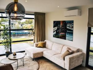 a living room with a couch and a table at Holiday Home MarinaPark Nieuw Loosdrecht-3 by Interhome in Loosdrecht