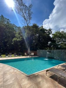 una piscina con una fuente en un patio en Apart-hotel Nova Friburgo Com café da manhã en Nova Friburgo