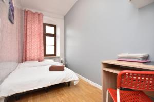 a small bedroom with a bed and a desk at City Central Hostel - Pokoje prywatne in Wrocław