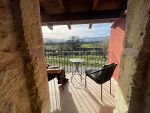a person sitting on a balcony with a table and chairs at La Casa del Cantero in Pinilla del Valle