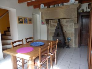 a dining room with a wooden table and a fireplace at Gîte Lironcourt, 3 pièces, 5 personnes - FR-1-589-118 in Lironcourt