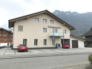 a building with two cars parked in front of it at Modern little gem close to lake Thun in Reutigen