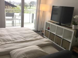 a bedroom with a flat screen tv and a bed at Modern little gem close to lake Thun in Reutigen