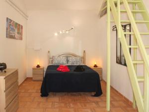 a bedroom with a bed with a black blanket and a ladder at Holiday Home Quinta Dahlia by Interhome in Pegões
