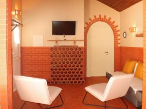 a room with two chairs and a tv on a wall at Holiday Home Quinta Dahlia by Interhome in Pegões