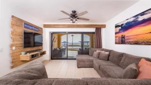a living room with a couch and a flat screen tv at Right on the Beach! 1 Bedroom Ground Floor Ocean Front in Puerto Peñasco