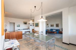 a dining room and kitchen with a glass table and chairs at Villa Nettuno- Bluchalet in Zoagli