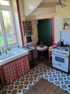 a kitchen with a sink and a stove at MAISON ST CHRISTOPHE in Lézardrieux