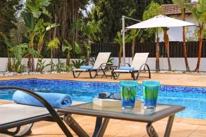 uma mesa com copos ao lado de uma piscina em Villa Lara - 3bed Bangalow with Large Pool em Agia Napa