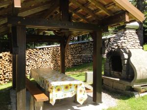 ein Picknick-Unterstand mit einer Bank und einem Ofen in der Unterkunft Charmant Gîte avec Garage et Local Vélos au Pied des Pistes de La Bresse - FR-1-589-127 in La Bresse