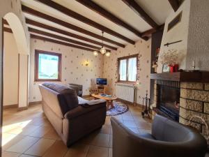 a living room with a couch and a fireplace at Maison tranquille avec cheminée près de Gérardmer - FR-1-589-142 in Gerbépal